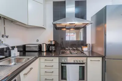 a kitchen with a stove top oven next to a sink at FLH Funchal Balcony Apartment with Sea View in Funchal