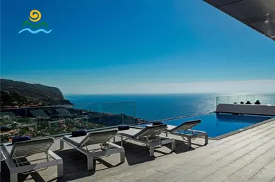 a balcony with chairs and a swimming pool at OurMadeira - Seacrest in Ponta do Sol