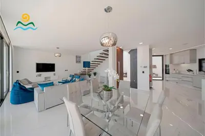 a dining room and living room with a glass table at OurMadeira - Seacrest in Ponta do Sol