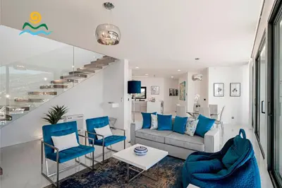 a living room with blue chairs and a couch at OurMadeira - Seacrest in Ponta do Sol