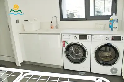 a laundry room with two washing machines and a sink at OurMadeira - Seacrest in Ponta do Sol