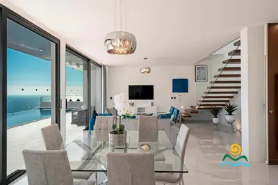 a dining room with a glass table and chairs at OurMadeira - Seacrest in Ponta do Sol