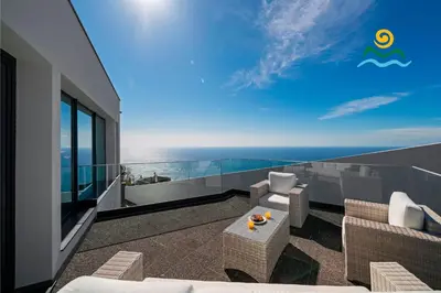 a balcony with chairs and a view of the ocean at OurMadeira - Seacrest in Ponta do Sol