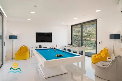 a pool table in a living room with yellow chairs at OurMadeira - Seacrest in Ponta do Sol