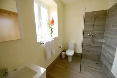 a bathroom with a shower and a toilet and a window at Comfortable apartment with shared pool in Prazeres, 150 m² in Campanário