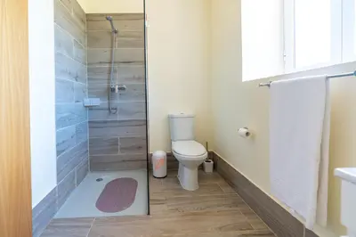 a bathroom with a toilet and a shower at Spacious apartment with pool in Prazeres - 150m² in Campanário