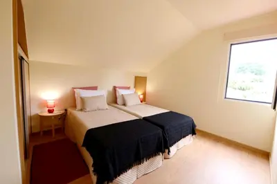 a bedroom with a large bed and a window at Charming Apartment in Prazeres with Shared Pool - 150 m² in Campanário
