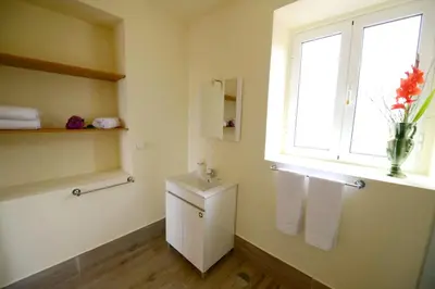 a bathroom with a toilet and a window and a sink at Charming Apartment in Prazeres with Shared Pool - 150 m² in Campanário