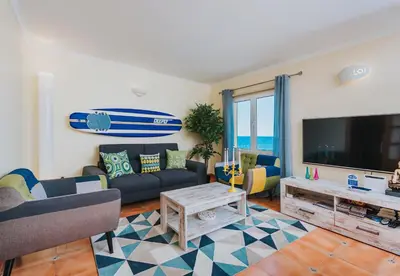 a living room with a couch and a surfboard on the wall at The Yellow House in Paul do Mar