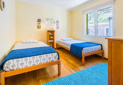 a bedroom with two beds and a window at The Yellow House in Paul do Mar