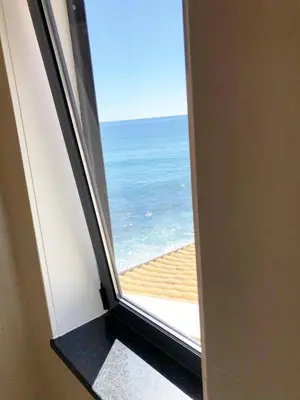 a window with a view of the ocean at The Yellow House in Paul do Mar