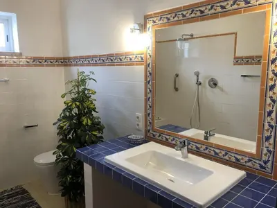 a bathroom with a sink and a mirror at Charming Villa with Heated Pool near Sandy Beach, Hiking, Golf and Wineries in Luz
