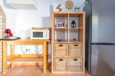 a kitchen with a table and a microwave at Casa Oceano-Ave do Mar in Raposeira