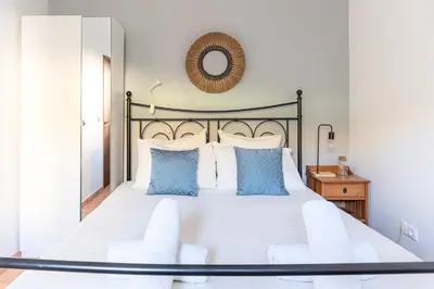 a bedroom with a large bed with blue pillows at Casa Oceano-Ave do Mar in Raposeira