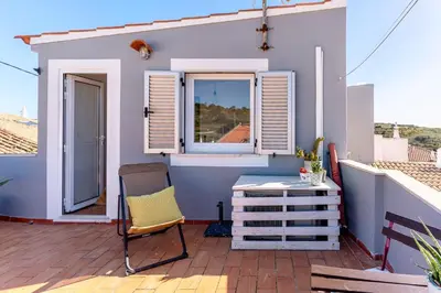 a small balcony with a chair and a window at Casa Oceano-Mar a vista in Raposeira