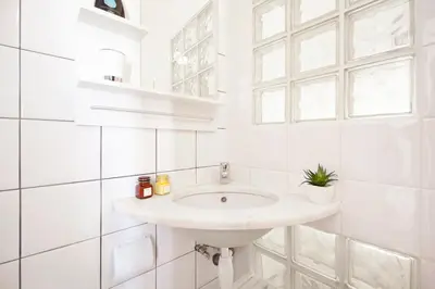 a white bathroom with a sink and a window at Casa Oceano-Mar a vista in Raposeira
