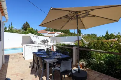a patio with a table and an umbrella at Villa Mirembe in Luz