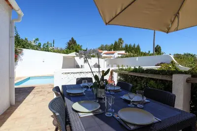 a blue table with plates and glasses on a patio at Villa Mirembe in Luz