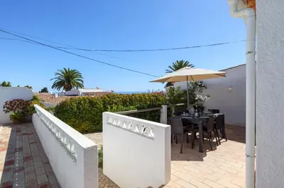 a patio with a table and an umbrella at Villa Mirembe in Luz