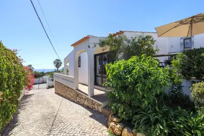 a white building with an umbrella on a street at Villa Mirembe in Luz