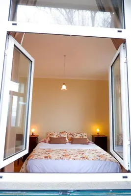 a bedroom with a large bed with two windows at Avó Lucindinha House - Porto Moniz in Porto Moniz