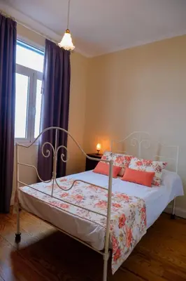 a bedroom with a bed with red pillows at Avó Lucindinha House - Porto Moniz in Porto Moniz