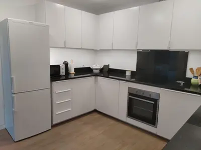 a kitchen with white cabinets and a refrigerator at Avó Lucindinha House - Porto Moniz in Porto Moniz