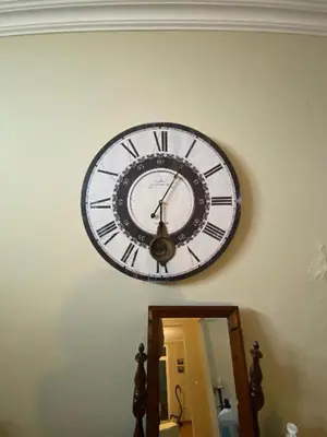 a clock hanging on the wall above a mirror at Avó Lucindinha House - Porto Moniz in Porto Moniz