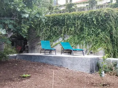 two blue chairs sitting on a stone bench at Avó Lucindinha House - Porto Moniz in Porto Moniz