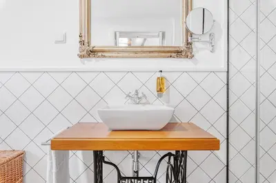 a bathroom with a white sink and a mirror at Quinta da Moscadinha in Camacha