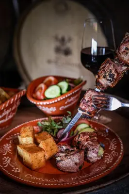 a table with a plate of food and a glass of wine at Quinta da Moscadinha in Camacha