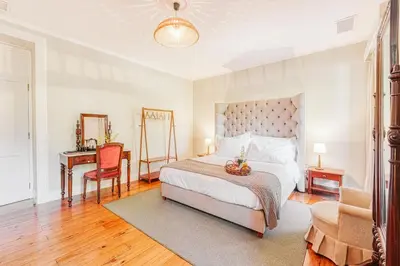 a bedroom with a bed and a desk and a chair at Quinta da Moscadinha in Camacha