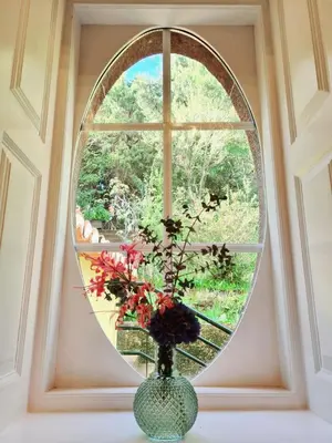 a round window with a vase with flowers in it at Quinta da Moscadinha in Camacha