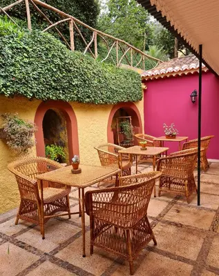 a patio with tables and chairs in front of a building at Quinta da Moscadinha in Camacha
