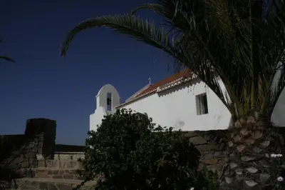 a white church with a palm tree in front of it at Beautiful Studio With Patio Carrapateira in Carrapateira