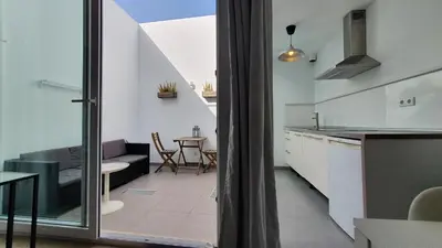 a kitchen and a living room with a table at Beautiful Studio With Patio Carrapateira in Carrapateira
