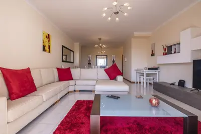 a living room with a white couch and red pillows at Casa Blanca II in Funchal