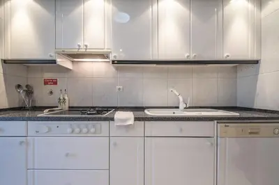 a white kitchen with white cabinets and a sink at Casa Blanca II in Funchal