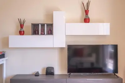 a living room with a tv and two white shelves at Casa Blanca II in Funchal
