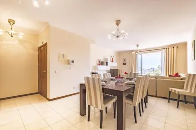 a dining room and living room with a table and chairs at Casa Blanca II in Funchal