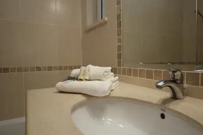 a bathroom with a sink and towels on a counter at Acácias, spacious apartment with sea view in Luz