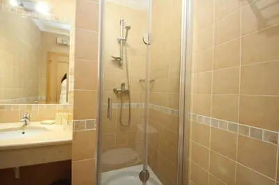 a bathroom with a shower and a sink at Acácias, spacious apartment with sea view in Luz