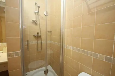 a bathroom with a shower with a toilet and a sink at Acácias, spacious apartment with sea view in Luz