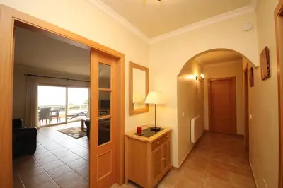 a living room with a hallway with a table and a door at Acácias, spacious apartment with sea view in Luz