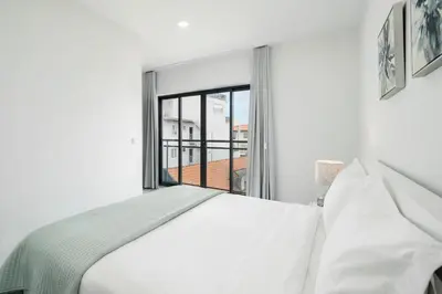 a bedroom with a white bed and a large window at Santa Luzia I by An Island Apart in Funchal