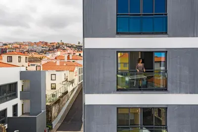 a woman standing on a balcony looking out of a building at Santa Luzia I by An Island Apart in Funchal