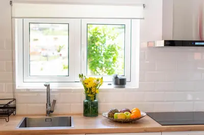 a kitchen counter with a bowl of fruit and a window at Casa do Bago in São Vicente
