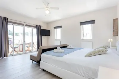 a bedroom with a large bed and a balcony at Mariners (5) - Bright and stylish apartment - walk to the beach in Luz
