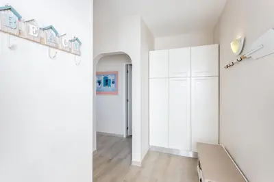 a bedroom with white cabinets and a room with a bed at Mariners (5) - Bright and stylish apartment - walk to the beach in Luz