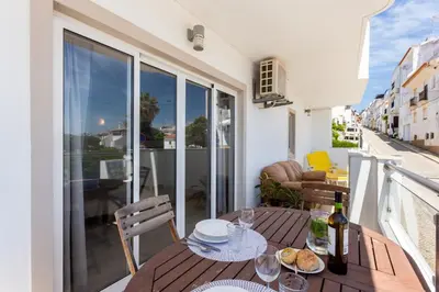 a balcony with a table with a bottle of wine at Mariners (5) - Bright and stylish apartment - walk to the beach in Luz